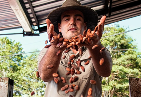 man holding cocoa beans